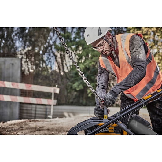 Worker attaches crane hook to Powershift Plate Compactor