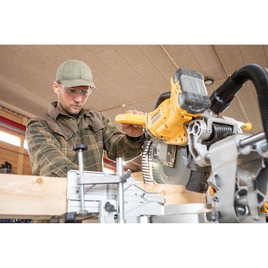 The DEWALT 18V XR 305mm Slide Mitre Saw being used by carpenter in wood shop
