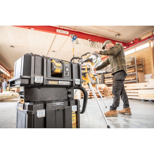 The DEWALT 18V XR 305mm Slide Mitre Saw being used by carpenter in wood shop