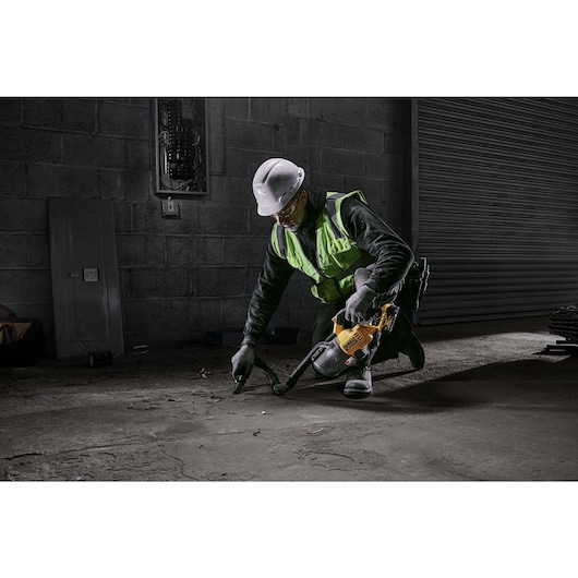 A TRADESMAN USING A DCV501L 18V XR L-CLASS STICK VAC TO CLEAN A SITE FLOOR