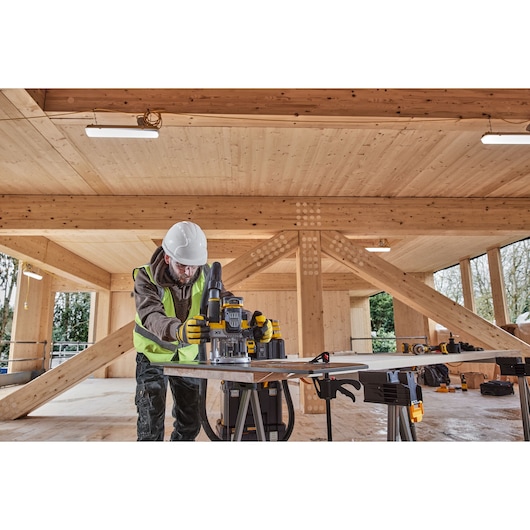 Construction worker using the 12mm plunge router on a housing construction site