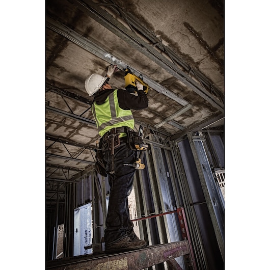 Trak-it C6 Gas Concrete Nailer being used by a person to install drywall track overhead into ceiling