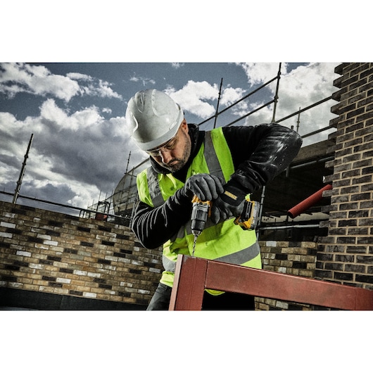 Drilling into metal rail using HSS drill bit on a construction site