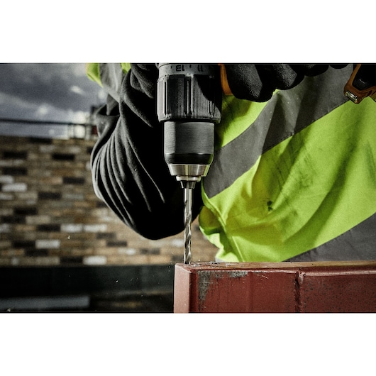 Close up drilling of a metal rail using HSS drill bit on a construction site