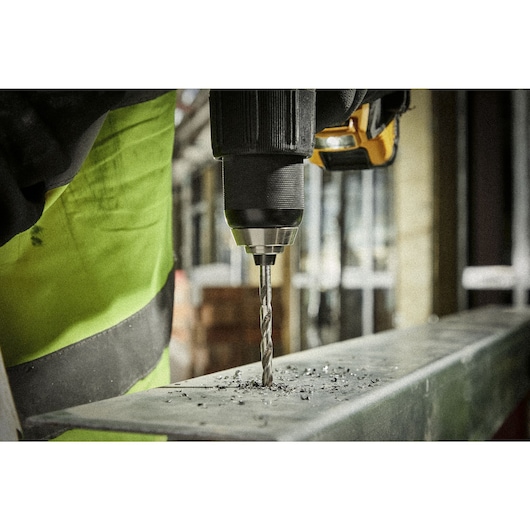 Close up metal drilling using HSS drill bit on a construction site