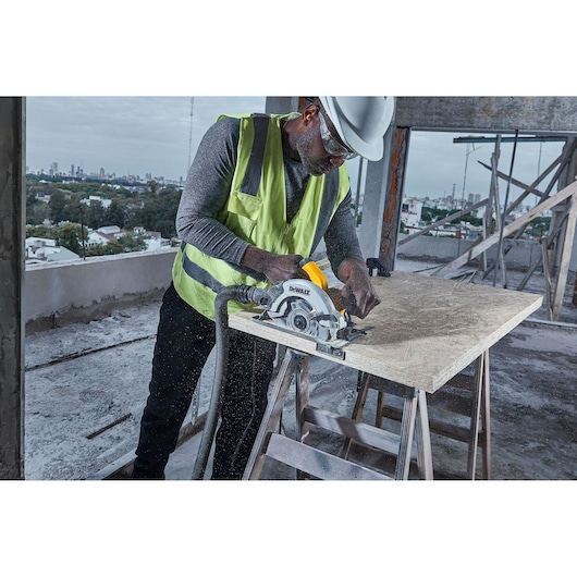Corded Circular Saw Cutting Wood with Connection to Dust Extractor