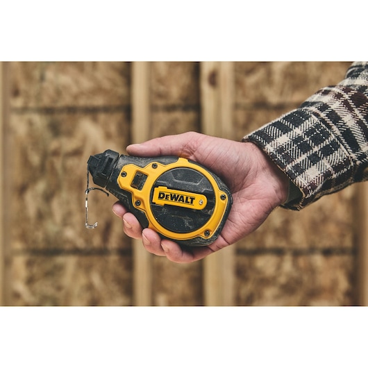 Holding the DEWALT® Bi-Material Chalk Reel Kit (Blue)