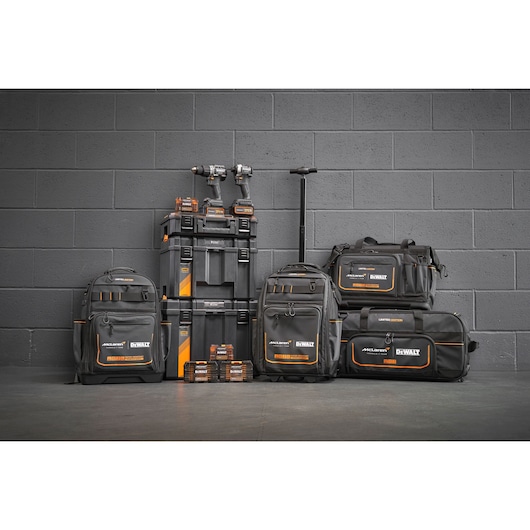 Limited Edition DEWALT/McLaren storage bags, Tstak trolley, impacts and accessory boxes stand in front of a grey wall.