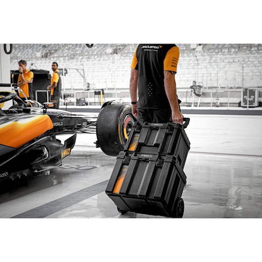 Limited Edition DEWALT/McLaren TSTAK 3-IN-1 Rolling Workshop Bundle being used in the pitlane garage pulled by pit crew